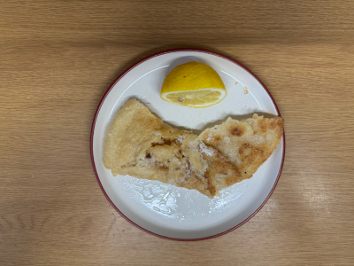 Photo of a pancake on a plate with half a lemon