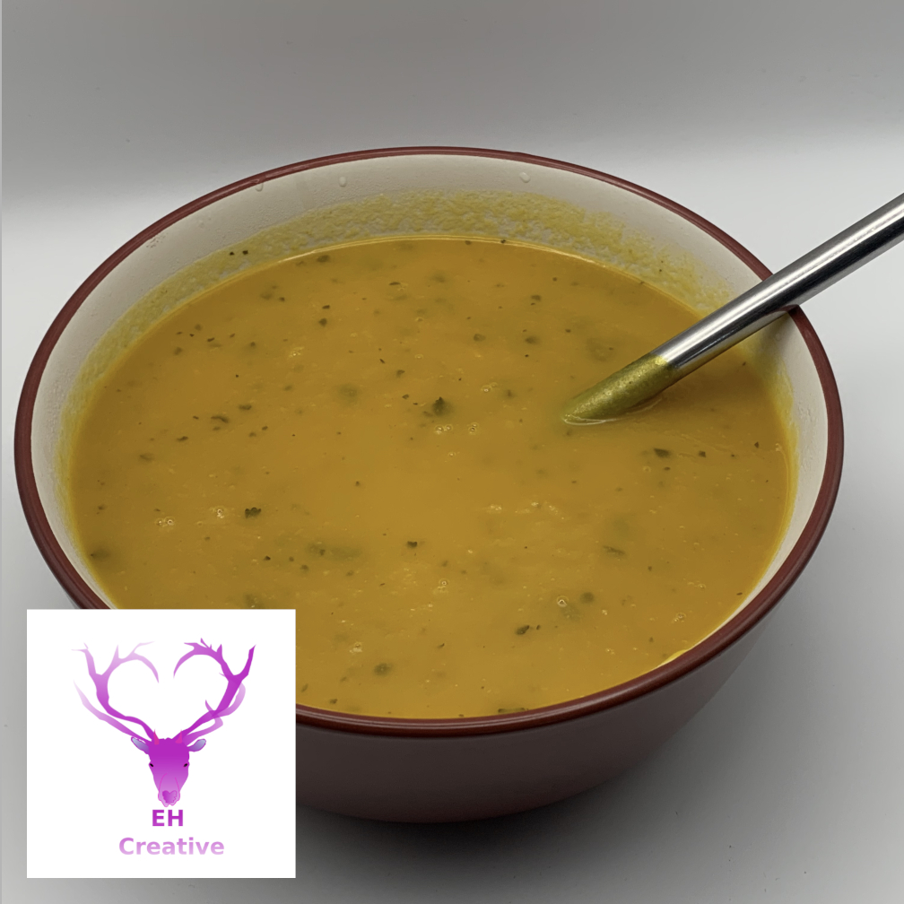 A bowl of carrot soup with spoon